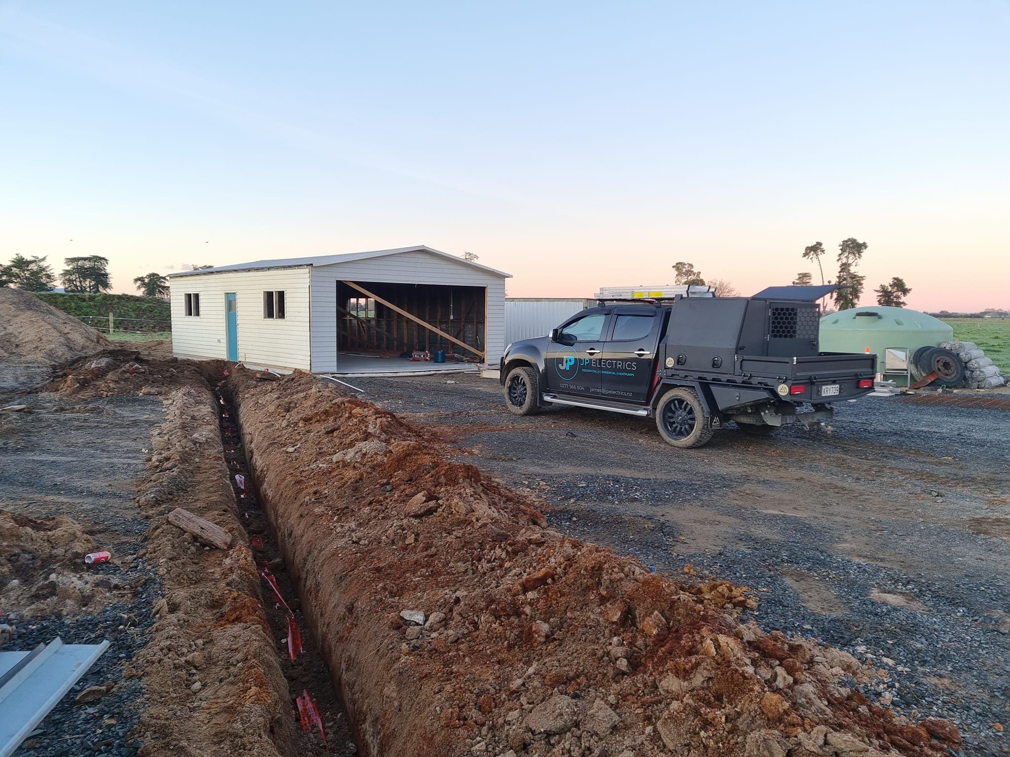 JP Electrics work vehicle on a rural Waikato job site at dusk